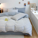 ensemble literie bleu rayures horizontales taies oreillers couverture pliée moderne minimaliste