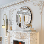 Miroir rond décoratif accroché au-dessus d'une cheminée