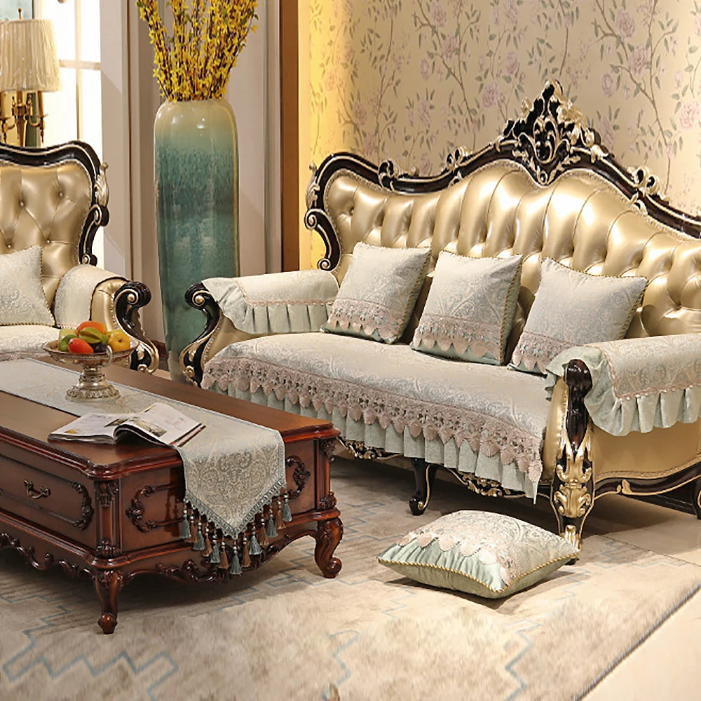 Un salon de luxe décoré avec un canapé capitonné beige, des coussins ornementés, une table de bout sculptée et un vase de fleurs dans un style élégant et élégant.