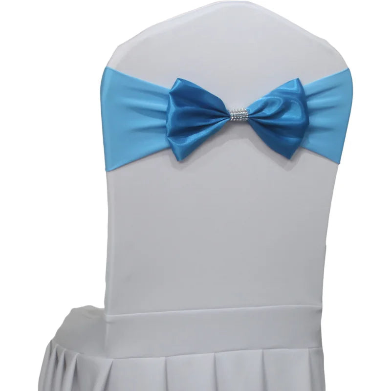 Une chaise blanche décorée d'un élégant nœud papillon bleu avec un ornement en strass au centre.