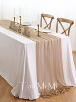 Une table élégante dressée avec de la vaisselle, des chandelles et des chaises en bois, créant une atmosphère chaleureuse et accueillante.