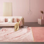 Pièce rose et blanche avec canapé et coussins confortables, lampe design suspendue et accessoires décoratifs.
