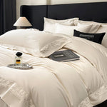 Parure de lit beige en coton égyptien avec broderie sur un lit