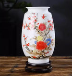 Vase en porcelaine blanc avec motifs de fleurs rouges, jaunes et bleues sur fond sombre.