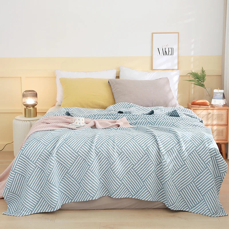 Chambre à coucher moderne avec une couverture en coton moelleuse et des oreillers confortables, créant une atmosphère paisible et accueillante.