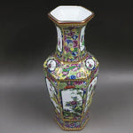 Vase de porcelaine décoré de motifs floraux colorés et de médaillons sur un fond blanc, créant une belle et sophistiquée conception.