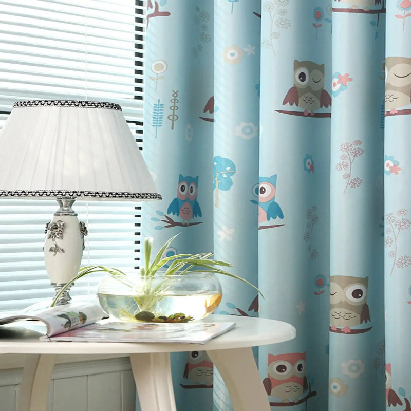 Rideaux bleu clair avec motifs hiboux colorés pour chambre d'enfant, ajoutant une touche ludique et décorative. Parfait pour créer une ambiance chaleureuse et accueillante. Accessoire idéal pour embellir la pièce.
