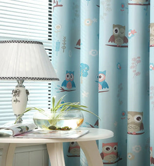 Rideaux bleu clair avec motifs hiboux colorés pour chambre d'enfant, ajoutant une touche ludique et décorative. Parfait pour créer une ambiance chaleureuse et accueillante. Accessoire idéal pour embellir la pièce.