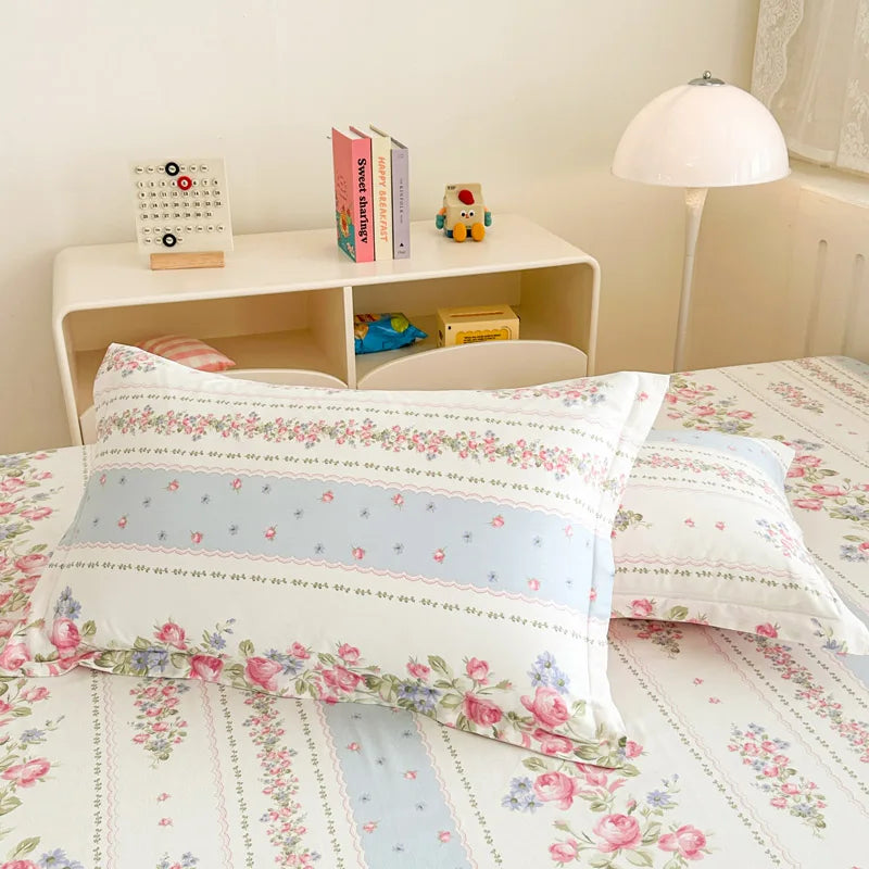 Un lit douillet avec des draps floraux et des rangements décoratifs crée une ambiance chaleureuse et accueillante dans cette chambre.