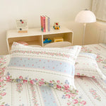 Un lit douillet avec des draps floraux et des rangements décoratifs crée une ambiance chaleureuse et accueillante dans cette chambre.