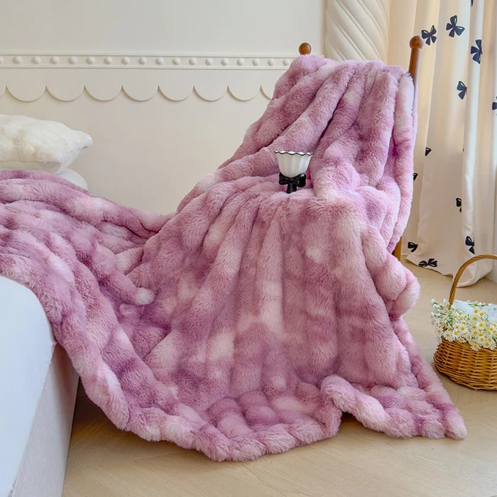 Une couverture moelleuse et douillette en fausse fourrure rose clair, parfaite pour se lover confortablement dans un lit douillet.