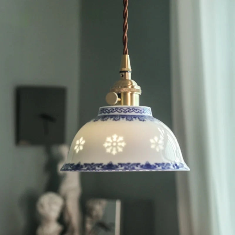 Luminaire suspendu blanc cuivre au-dessus d'une table à manger
