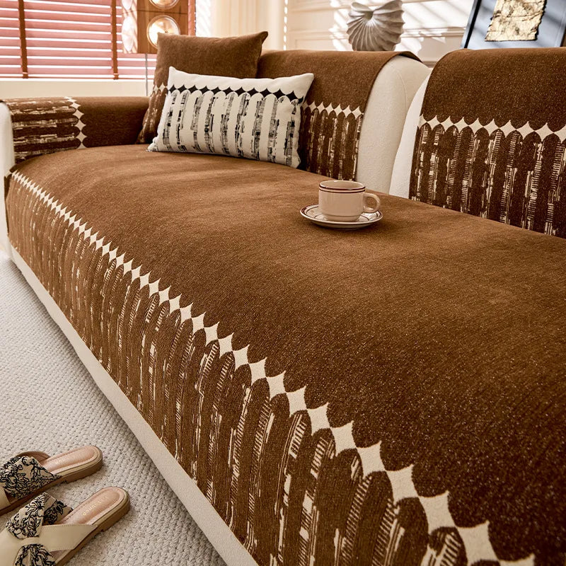 Un canapé confortable de couleur marron, avec des coussins décorés de motifs géométriques, posé sur un tapis clair dans un intérieur chaleureux.