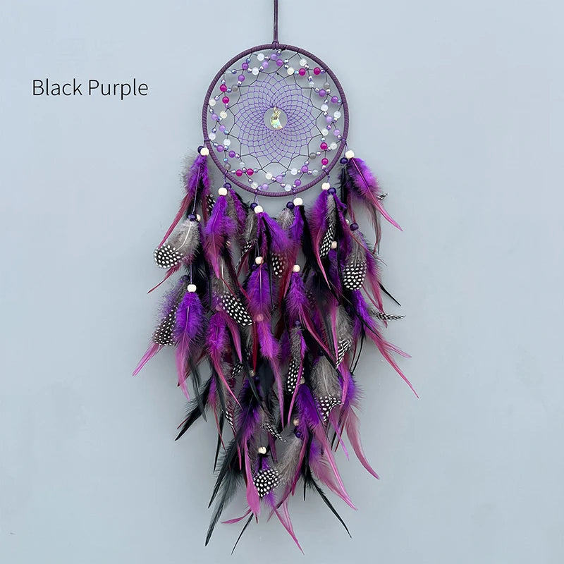 Attrapeur de rêves artisanal décoratif en noir et violet orné de plumes colorées.