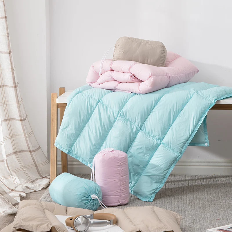 Une chambre confortable avec un lit douillet orné de couettes et d'oreillers rose pastel et bleu menthe.
