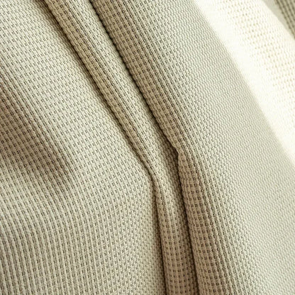 Gros plan sur un tissu beige avec un motif en maille serrée. Idéal pour la décoration intérieure ou la confection de vêtements modernes et élégants. Sa finition soignée et son design texturé apportent une touche de sophistication et de style à tout projet créatif.