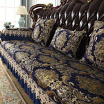 Très beau canapé en cuir marron avec des coussins décoratifs ornés de riches motifs floraux dorés sur fond bleu foncé, dans un cadre élégant et confortable.