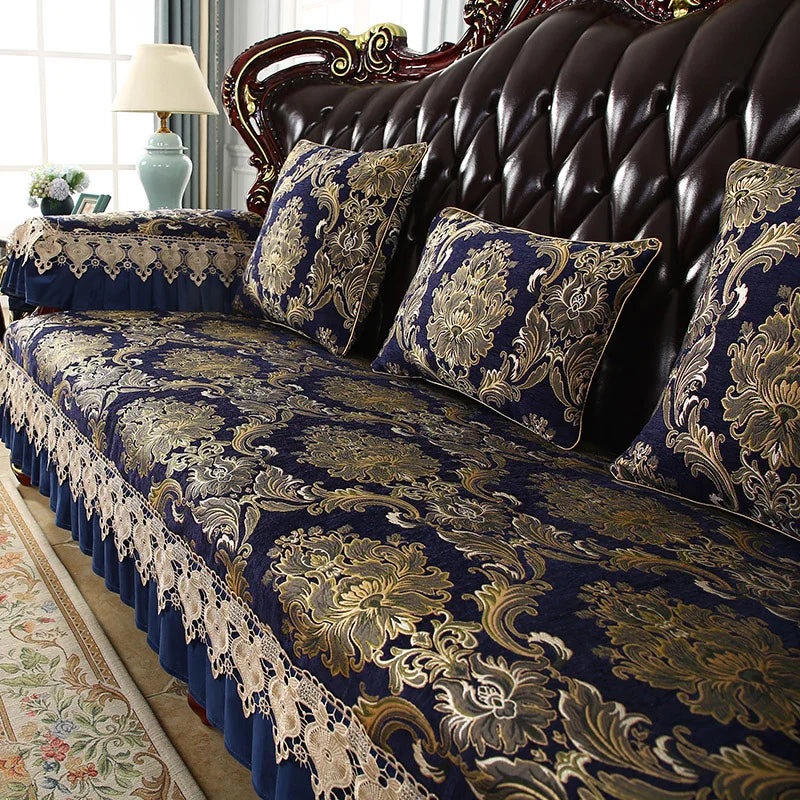Très beau canapé en cuir marron avec des coussins décoratifs ornés de riches motifs floraux dorés sur fond bleu foncé, dans un cadre élégant et confortable.