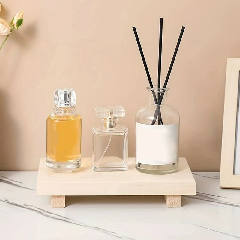 Plateau en bois rouge supportant des livres et bougies