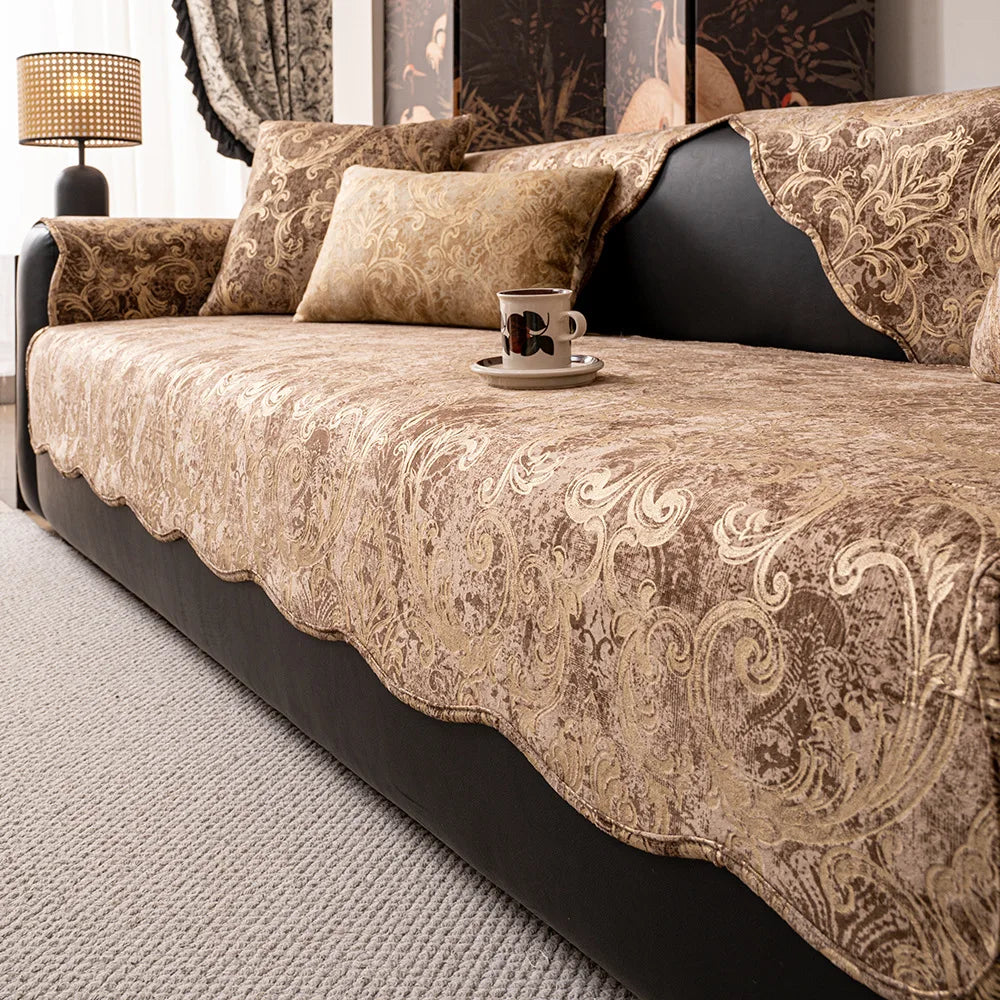 Coussins et couvertures beiges ornés de motifs floraux sur un canapé confortable dans un intérieur élégant.