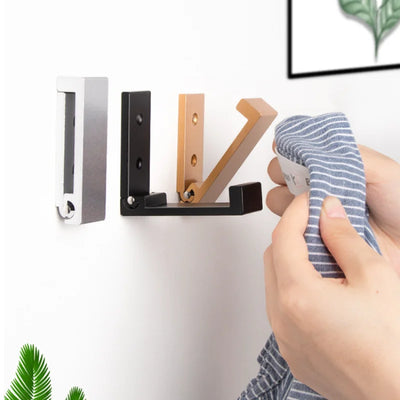 Patère murale pliante sans trou en aluminium noir sur un mur blanc
