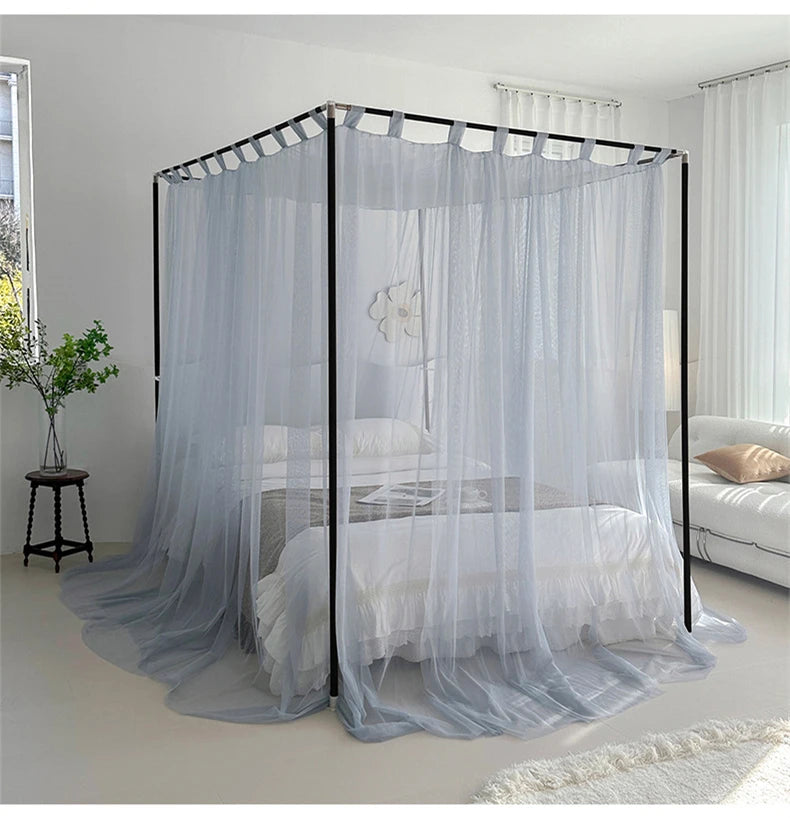 Cette image montre un lit à baldaquin avec des rideaux gris qui l'entourent, créant un effet cocooning et relaxant dans la pièce.