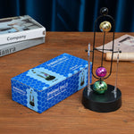 pendule newton sphères colorées structure métallique support transparent base circulaire décoration cinétique moderne