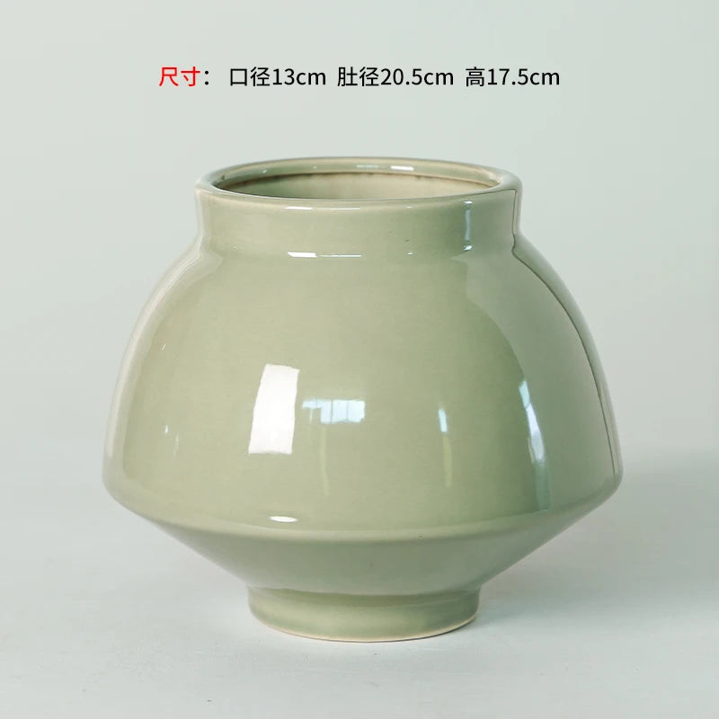 Ce vase en céramique de style vintage présente une forme ronde et une couleur pastel douce qui lui confèrent un aspect élégant et épuré.