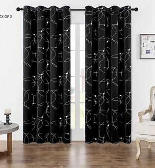 Rideau noir avec motifs circulaires blancs suspendu sur une baie vitrée, dans un salon lumineux au sol en bois.