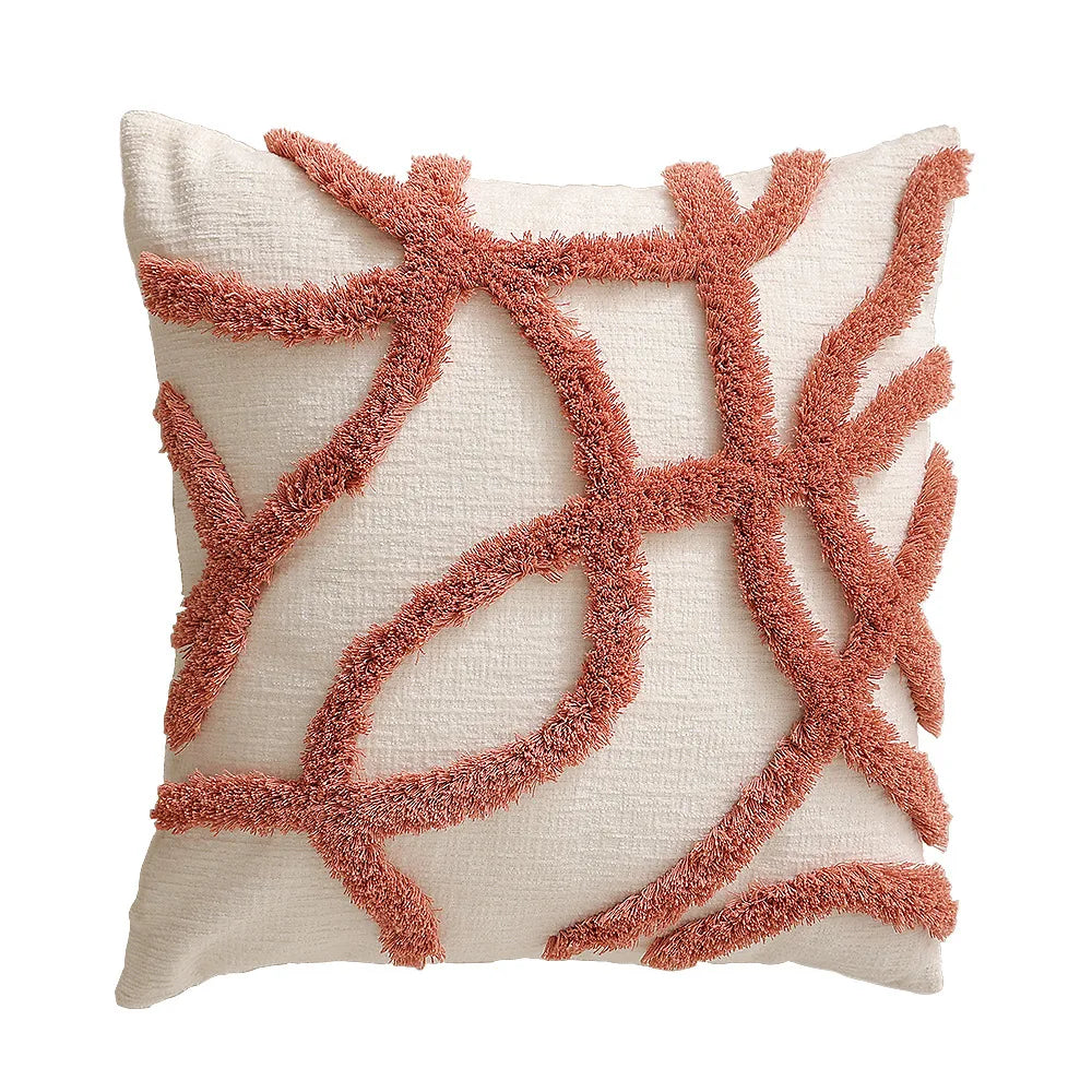 Coussin décoratif avec motif de corail rouge stylisé sur fond beige.