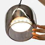 Lampe suspendue LED gris fumé au-dessus d'une table
