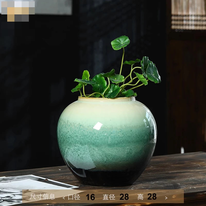 Vase en céramique verte avec plantes vertes en pot.