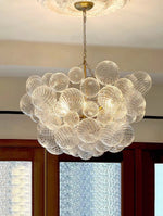 suspension lumineuse moderne verre transparent chaîne dorée led acier poli contemporain lumière chaude chambre