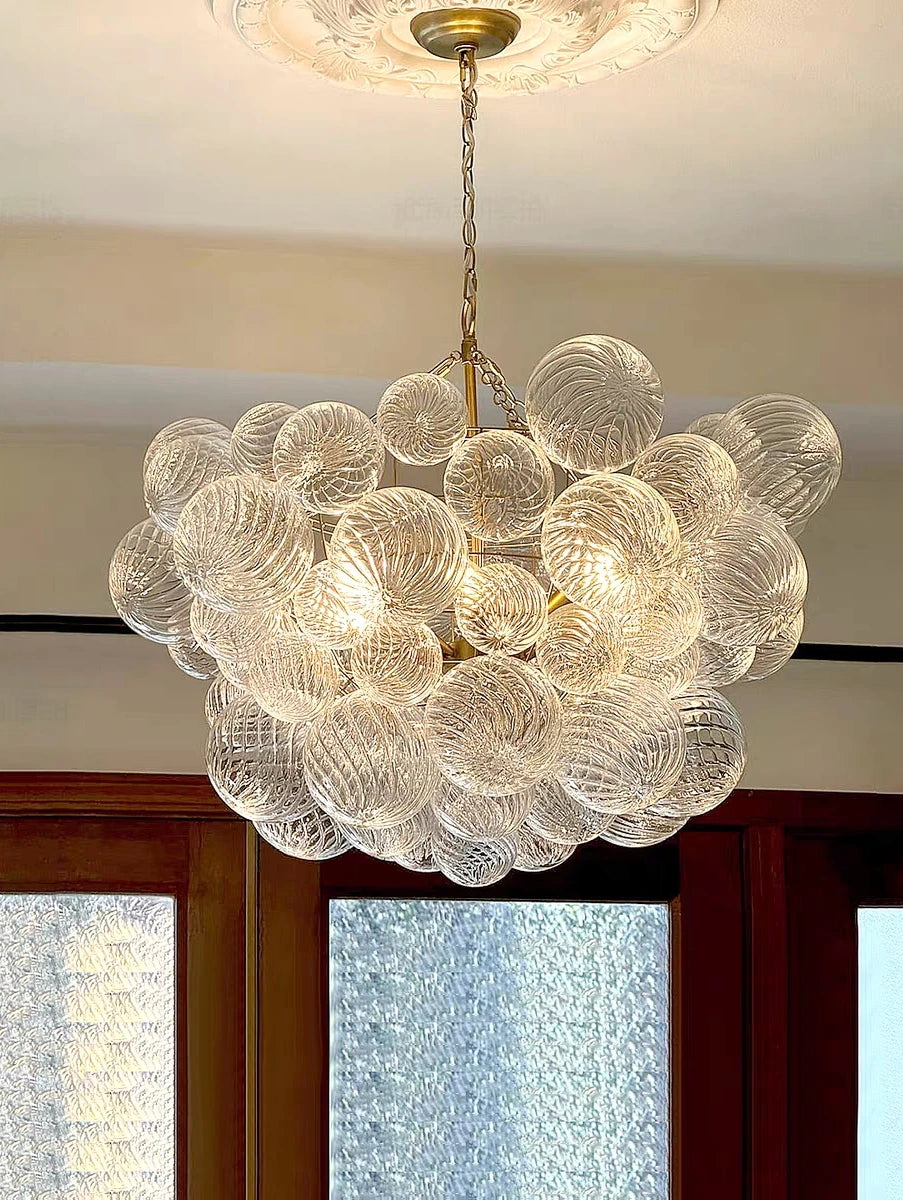 suspension lumineuse moderne verre transparent chaîne dorée led acier poli contemporain lumière chaude chambre