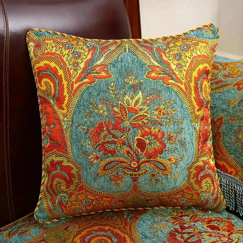 Élégant coussin décoratif aux motifs floraux colorés et textures tapissées de style oriental, créant une atmosphère chaleureuse et pittoresque.
