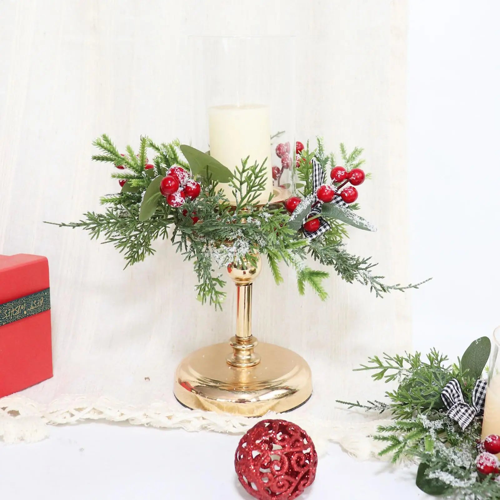 Couronne de bougie Noël noire avec pommes de pin et baies sur cheminée