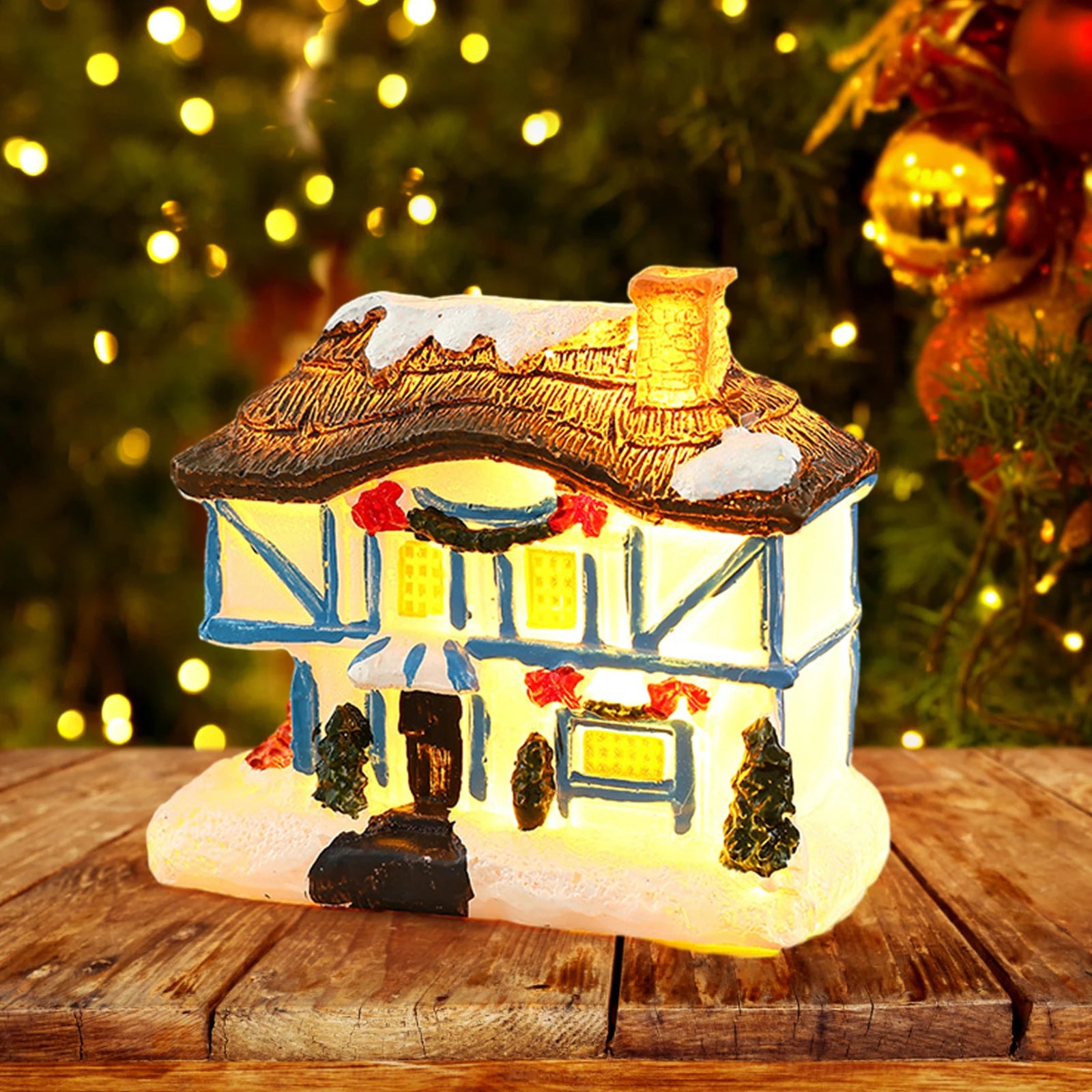 Maison de Noël en résine sur une table de bureau décorée