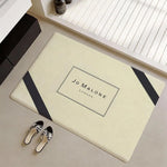 tapis moderne logo jo malone londres beige clair noir bordure diagonale résistant décoloration polyester