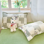 Une chambre confortable avec des oreillers moelleux, des peluches mignonnes et une décoration végétale apaisante, créant une atmosphère chaleureuse et relaxante.