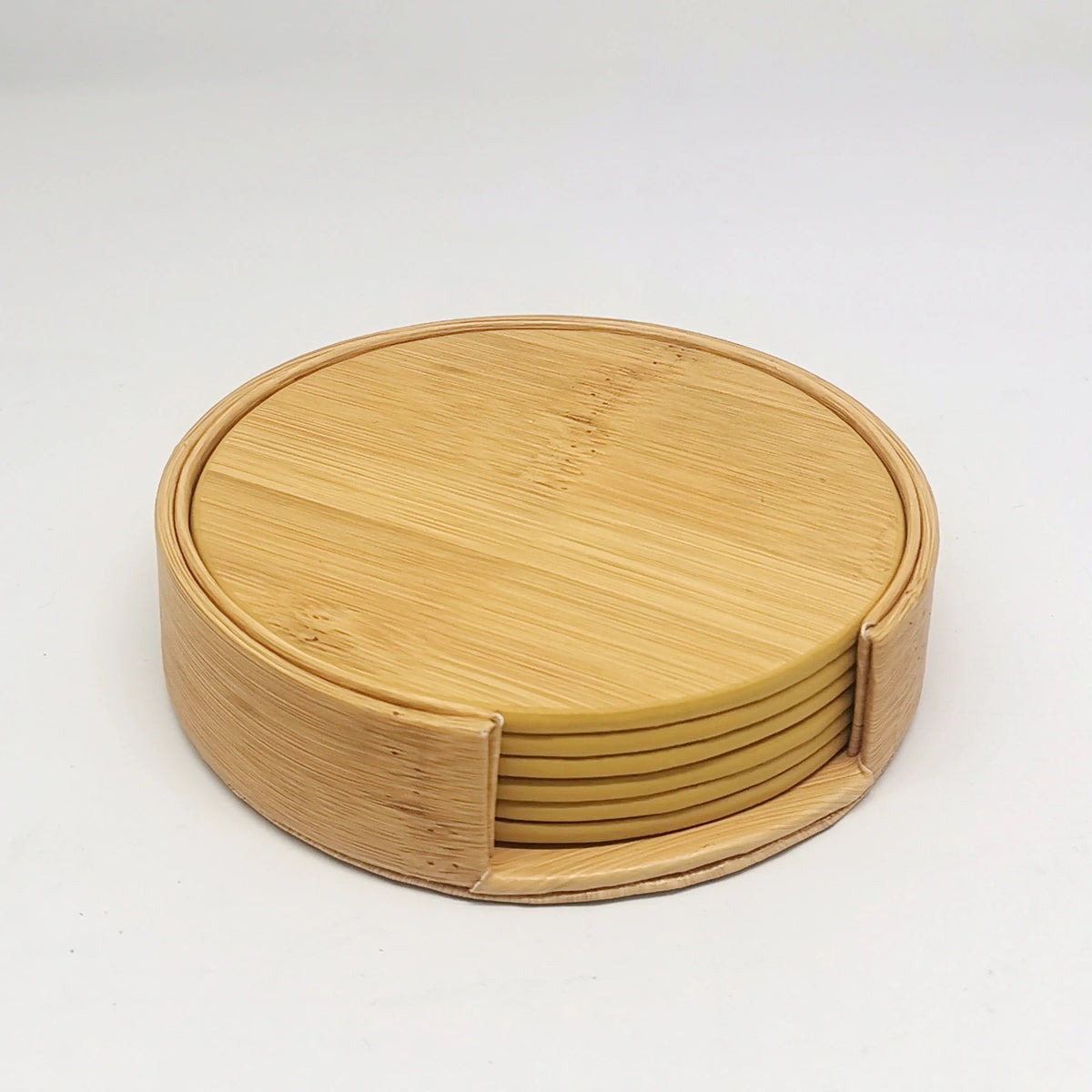 Un ensemble de sous-verres ronds en bambou naturel, empilés et rangés dans un bac rond.