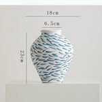 vase moderne blanc bleu rayures taches fleurs artificielles décoration intérieure unique table arrangement floral