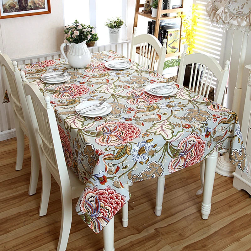 Une table à manger élégante avec une nappe fleurie, des assiettes et des fleurs, créant une ambiance chaleureuse et accueillante dans cette pièce.