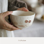 Bol en céramique blanc avec des motifs texturés et des anses en forme de boutons.