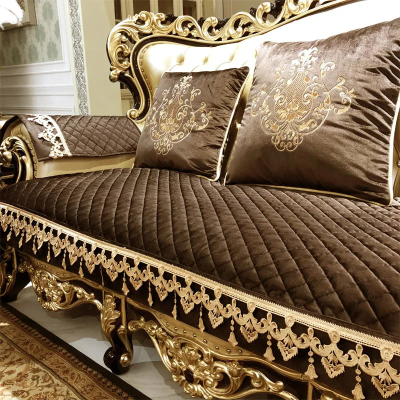 Un canapé de style baroque orné de détails dorés et de coussins en tissu brun foncé imprimé de motifs élégants.