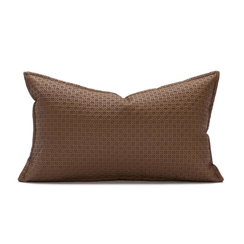 Un coussin rectangulaire brun avec un motif géométrique décoratif.