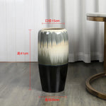 Un vase décoratif de 41 cm de hauteur et 15 cm de diamètre, avec un motif dégradé de couleurs neutres.