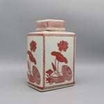 Pot décoratif en céramique blanc avec motifs floraux rouges et motifs géométriques.