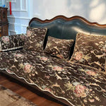 Parure de lit en velours damassé de couleurs chaudes et luxueuses, avec un motif floral élégant sur un fond sombre, créant une atmosphère sophistiquée et chaleureuse dans la chambre.