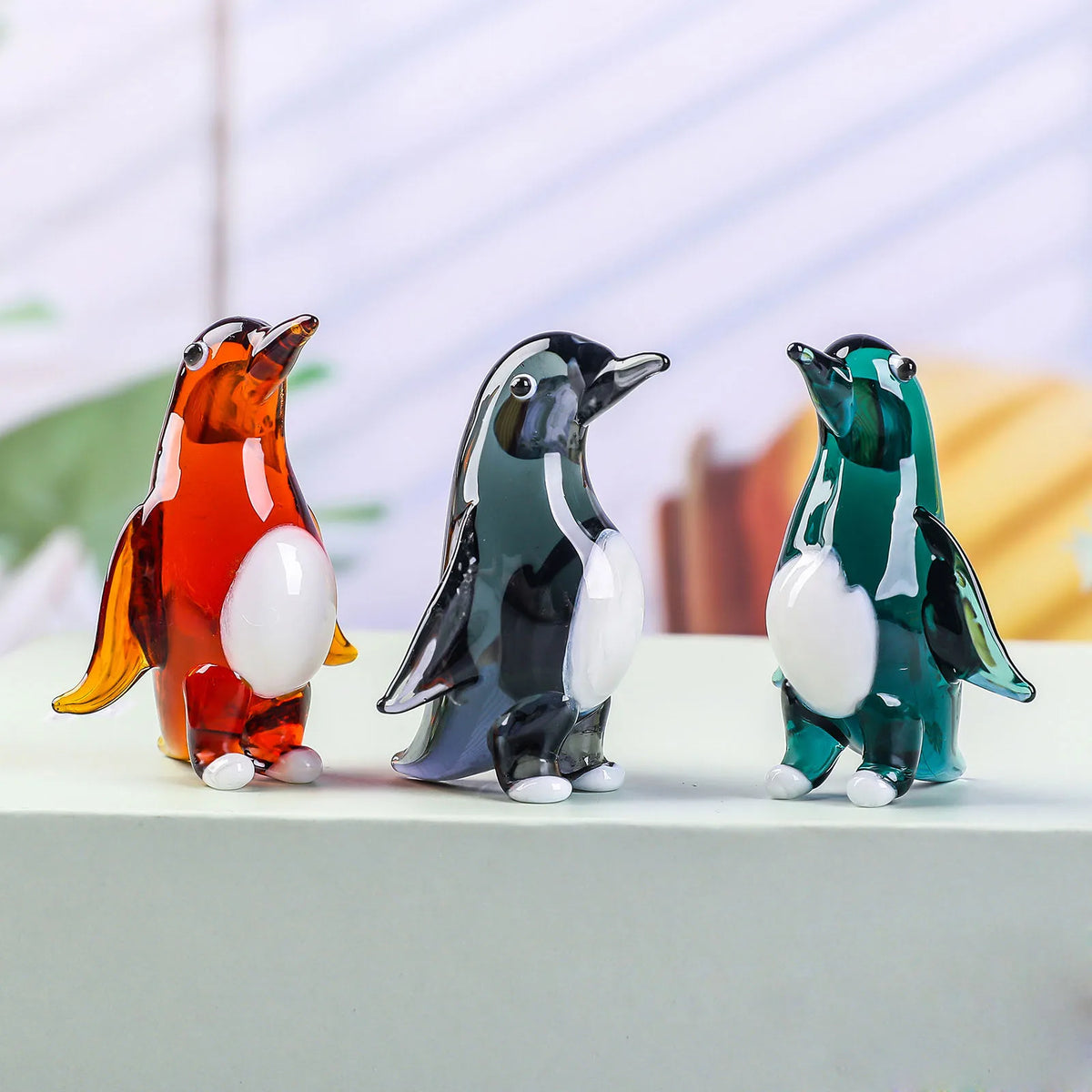 statuettes manchots transparents artisanales couleur verte orangée noire