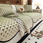 Motif floral répétitif en vert et blanc sur une belle literie de chambre comprenant un couvre-lit, des oreillers et une lampe de table.
